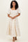 woman wearing a cream floral print maxi dress with puff sleeves and a tiered skirt