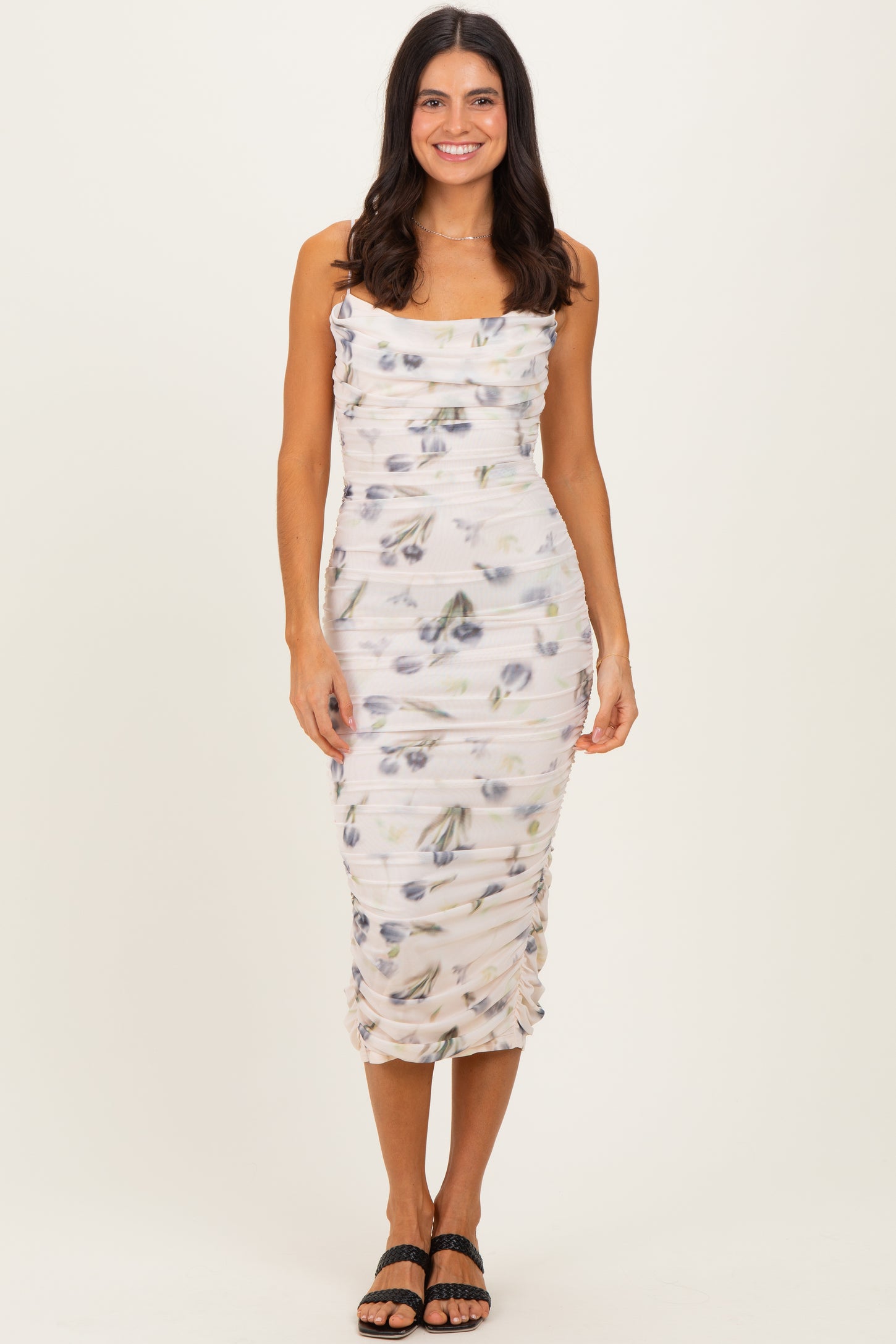 woman wearing a floral print fitted midi dress with ruched detailing and a square neckline