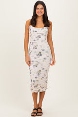 woman wearing a floral print fitted midi dress with ruched detailing and a square neckline