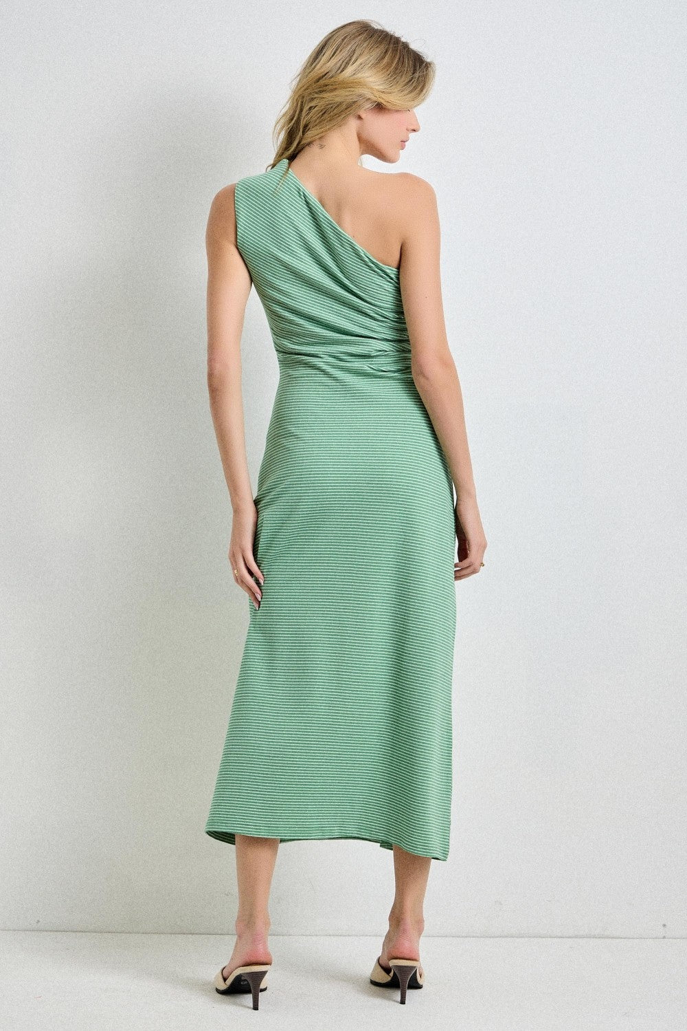 woman wearing a mint green one-shoulder midi dress with ruched detailing and a flowy skirt, seen from the back
