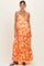woman wearing a floral pleated maternity maxi dress with a sweetheart neckline and a visible baby bump