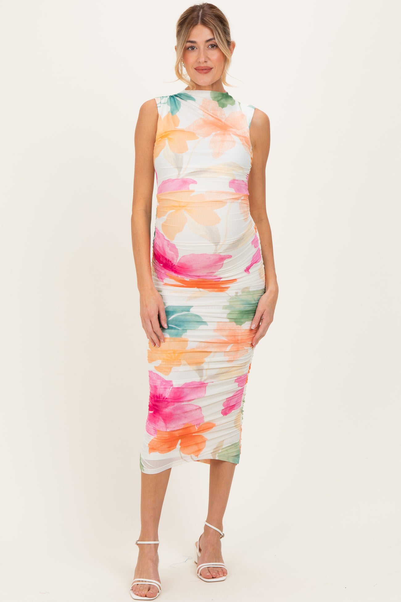 woman wearing a floral print maternity dress with a fitted silhouette and a visible baby bump