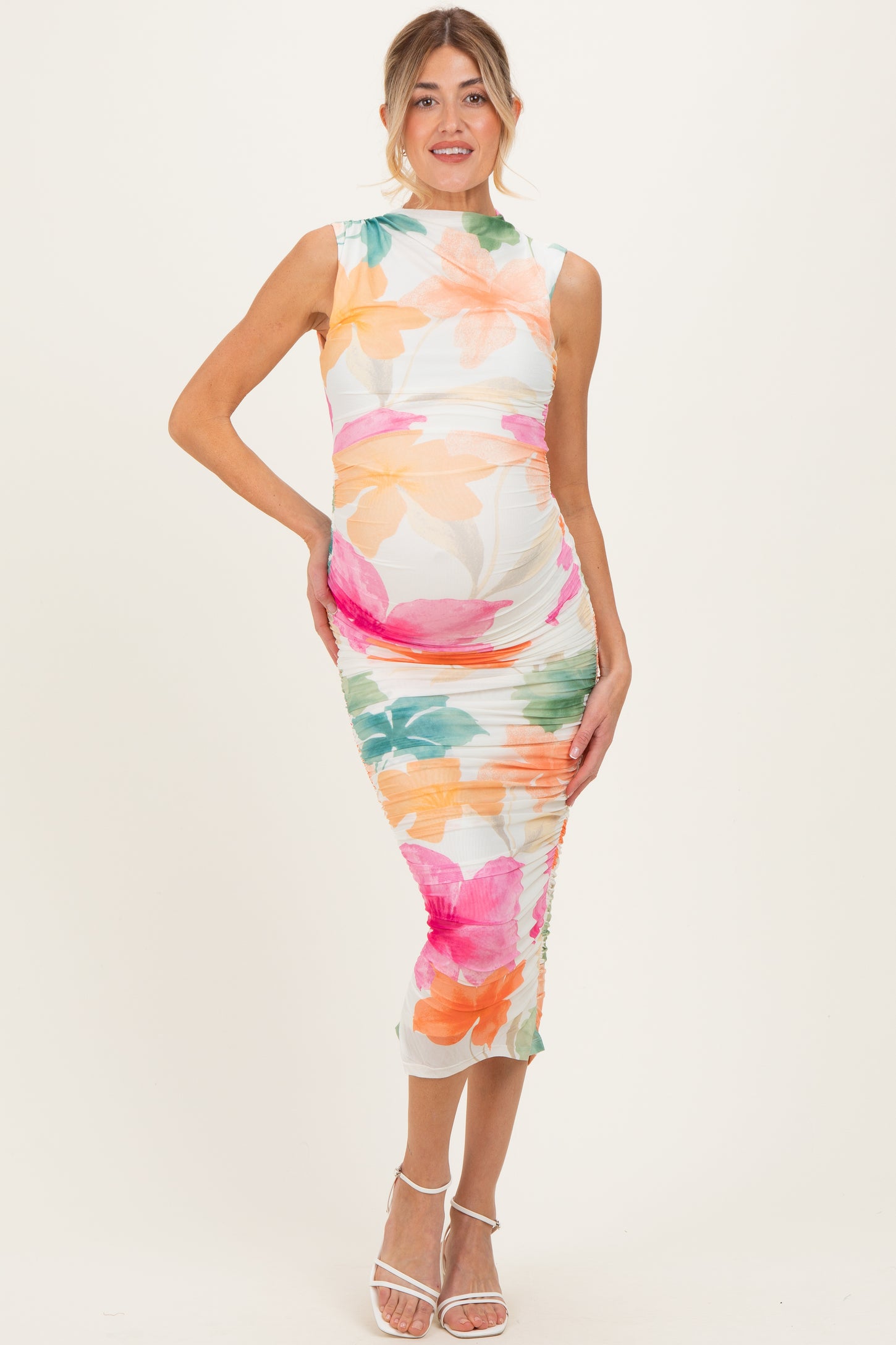 woman wearing a floral print maternity dress with a fitted silhouette, showcasing her baby bump