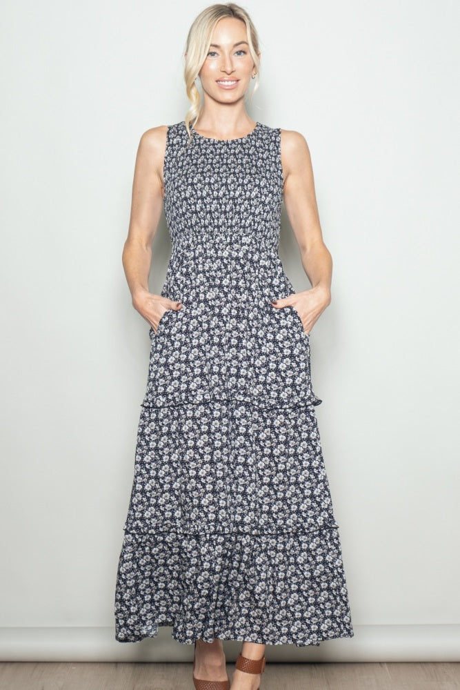 woman wearing a navy blue floral maxi dress with tiered skirt and pockets