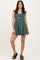 woman wearing a teal ruffled sleeve mini dress with a knot detail and cut-out waist