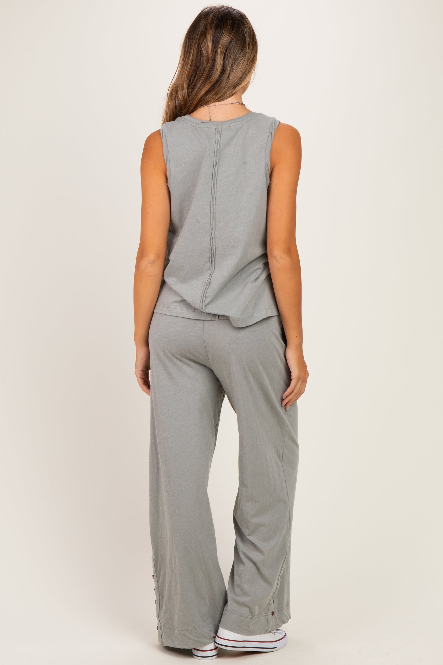 woman wearing a relaxed fit gray maternity tank top and coordinating wide-leg pants with side button details