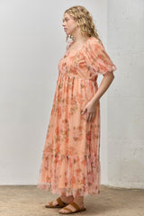 plus size woman wearing a peach floral maxi dress with puff sleeves and ruffle detailing