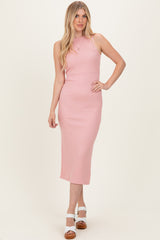 woman wearing a light pink ribbed midi dress with a sleeveless design and form-fitting silhouette