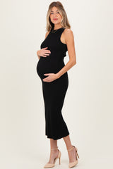 woman wearing a black ribbed maternity dress and holding her baby bump