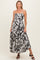 woman wearing a black and white leaf print maternity maxi dress with spaghetti straps and a flowy skirt