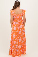 woman wearing an orange floral maternity maxi dress with short ruffled sleeves and a smocked back detail