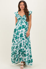woman wearing a green and white floral maternity maxi dress with flutter sleeves and a gathered bodice, showcasing a baby bump