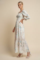woman wearing a long white floral maxi dress with puff sleeves and a tiered skirt