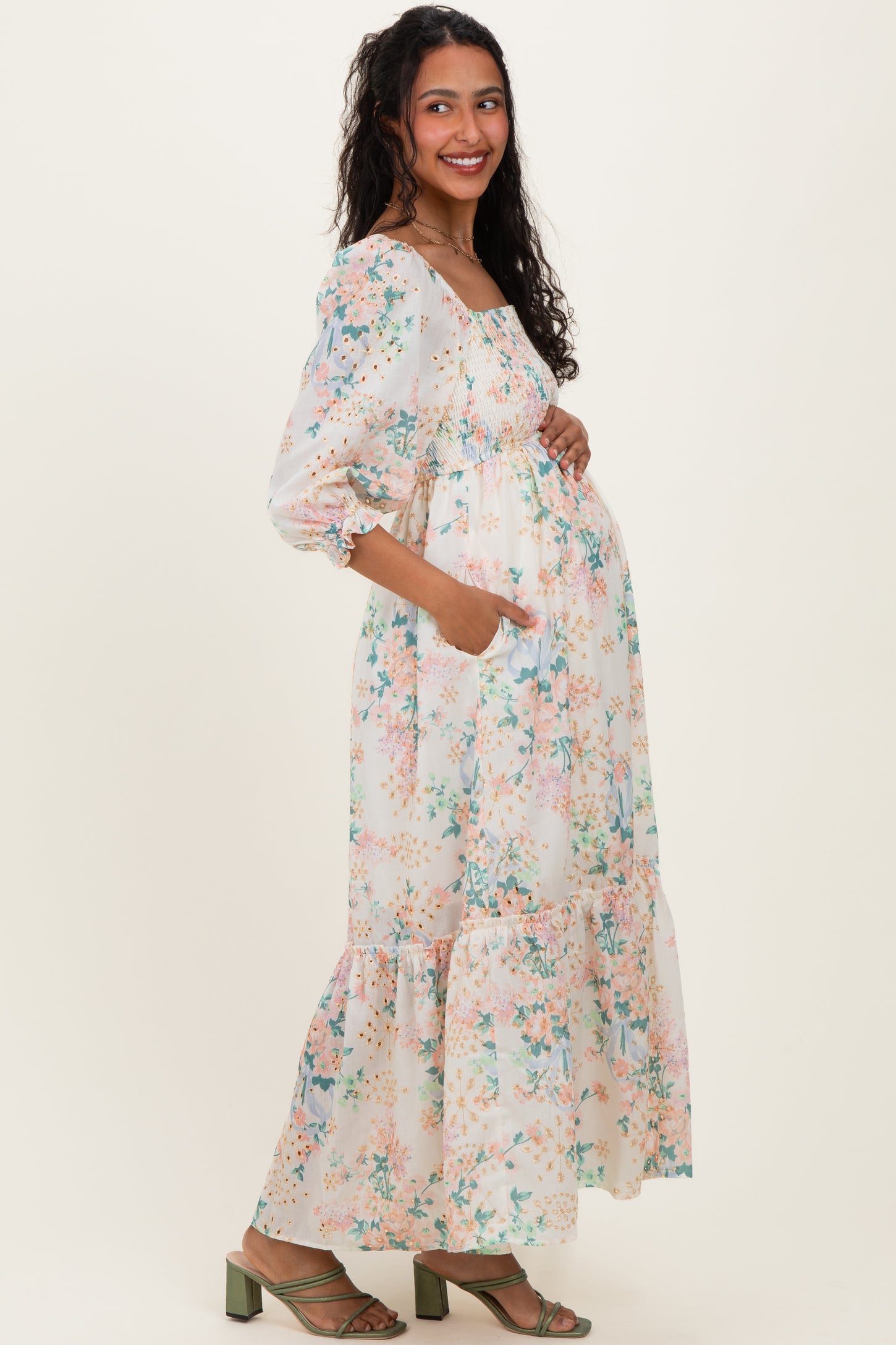 woman wearing a floral maternity maxi dress with puff sleeves and a baby bump visible