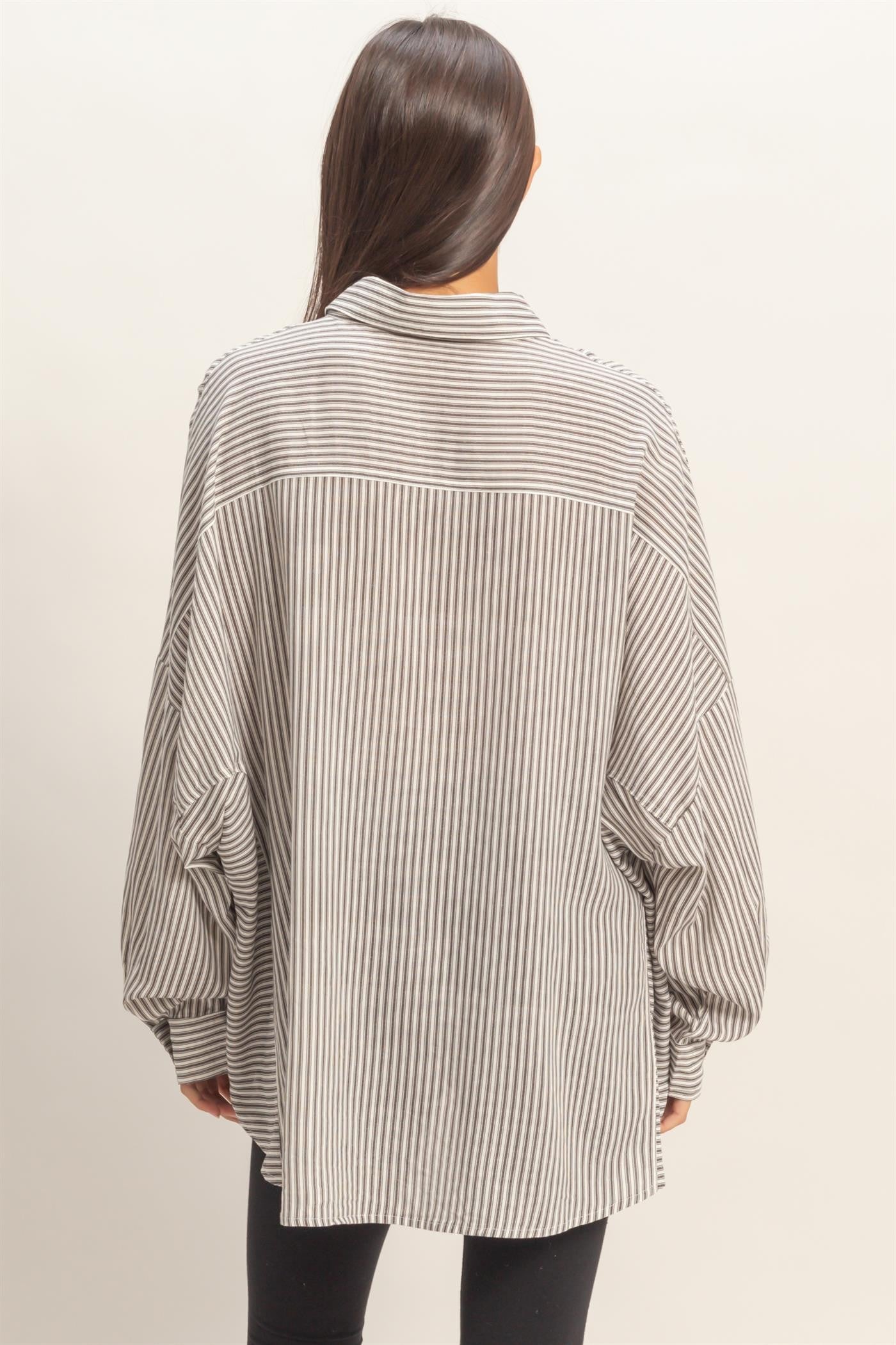 woman wearing a black and white striped oversized shirt with balloon sleeves, viewed from the back