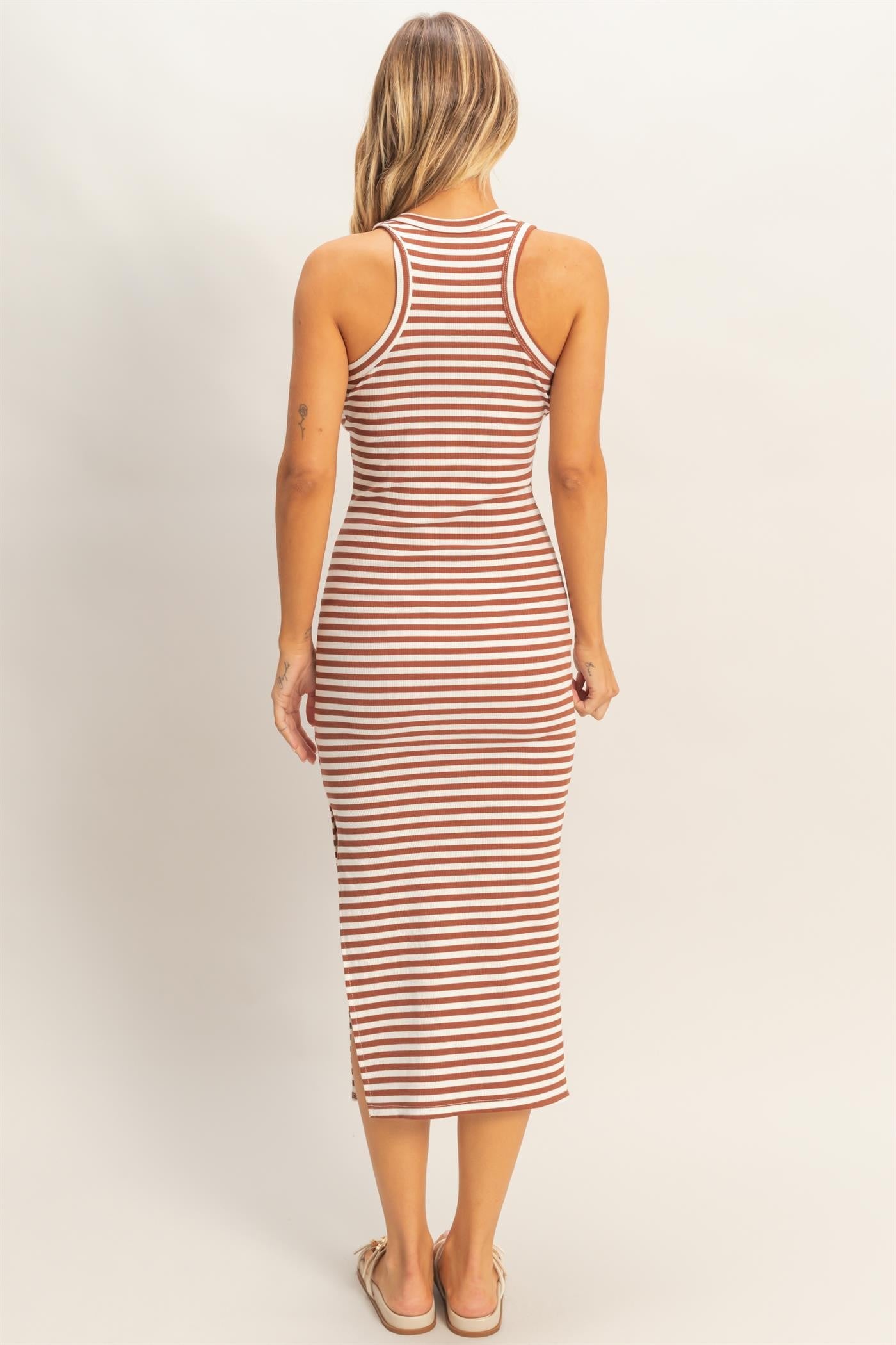 woman wearing a striped midi tank dress with a fitted silhouette and side slits, shown from the back