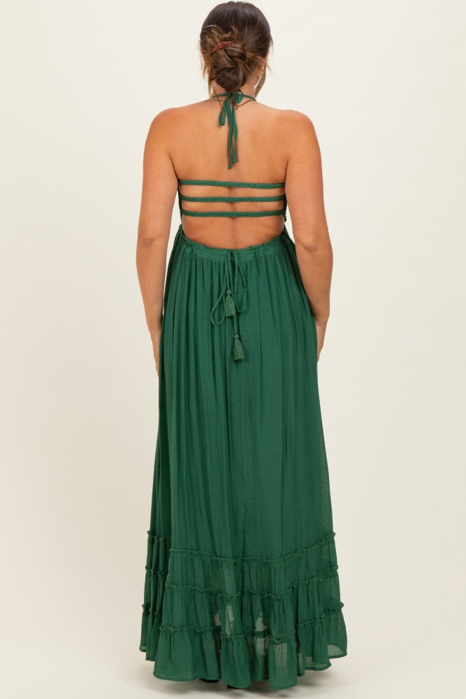 woman wearing a green maternity maxi dress with a back tie and tiered ruffle hem