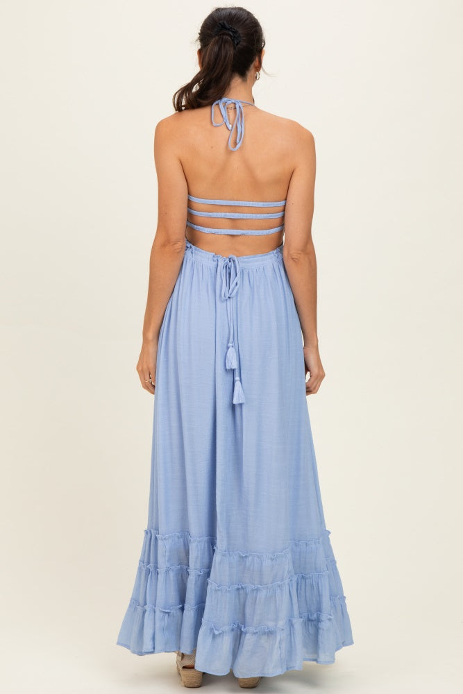woman wearing a light blue backless maxi dress with ruffle hem and tie straps