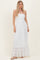 woman wearing a white strapless maxi dress with smocked bodice and tiered ruffle hem