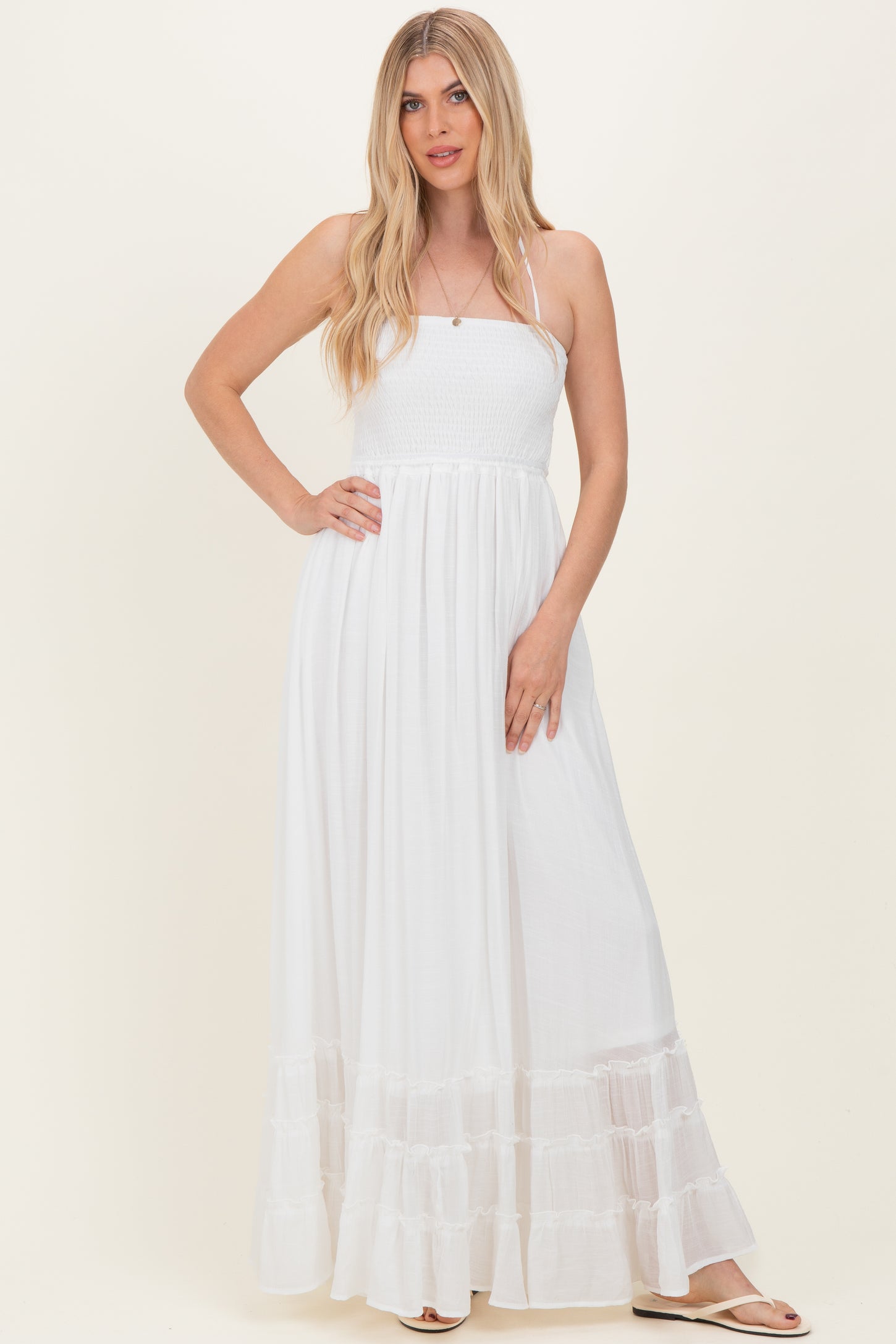 woman wearing a white maxi dress with a smocked bodice and tiered ruffle hem