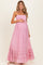 woman wearing a pink strapless maternity maxi dress with a smocked bodice and tiered ruffle hem, showing her baby bump