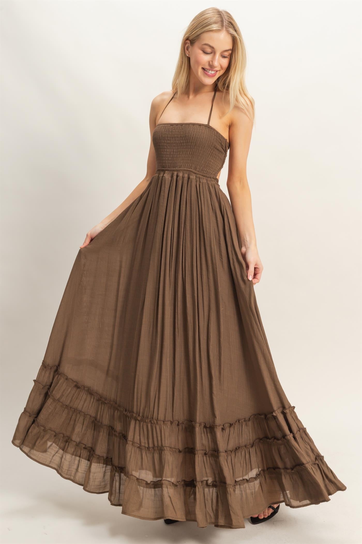 woman wearing a brown strapless maxi dress with a smocked bodice and tiered ruffle hem
