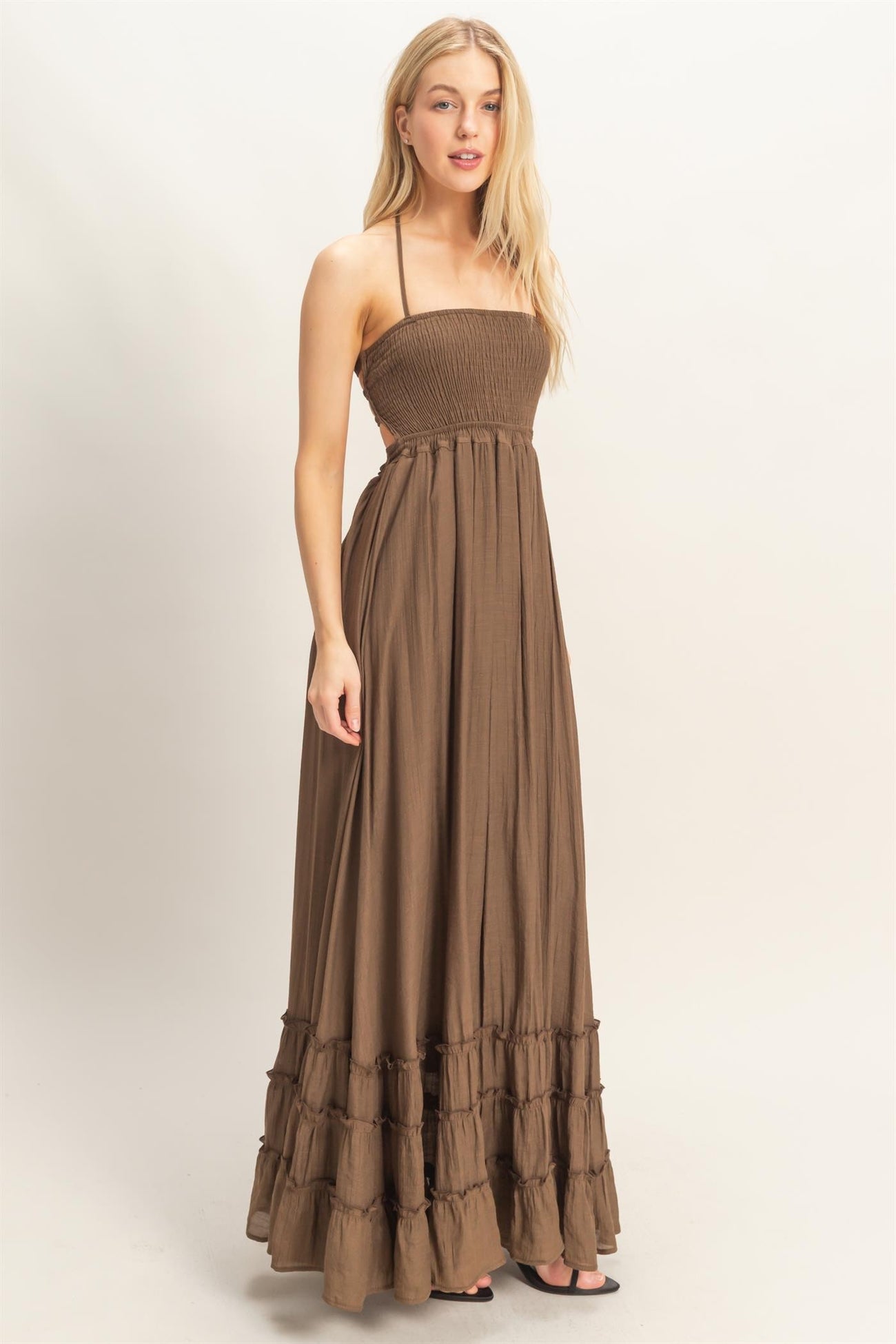 woman wearing a brown strapless maxi dress with a smocked bodice and tiered hem