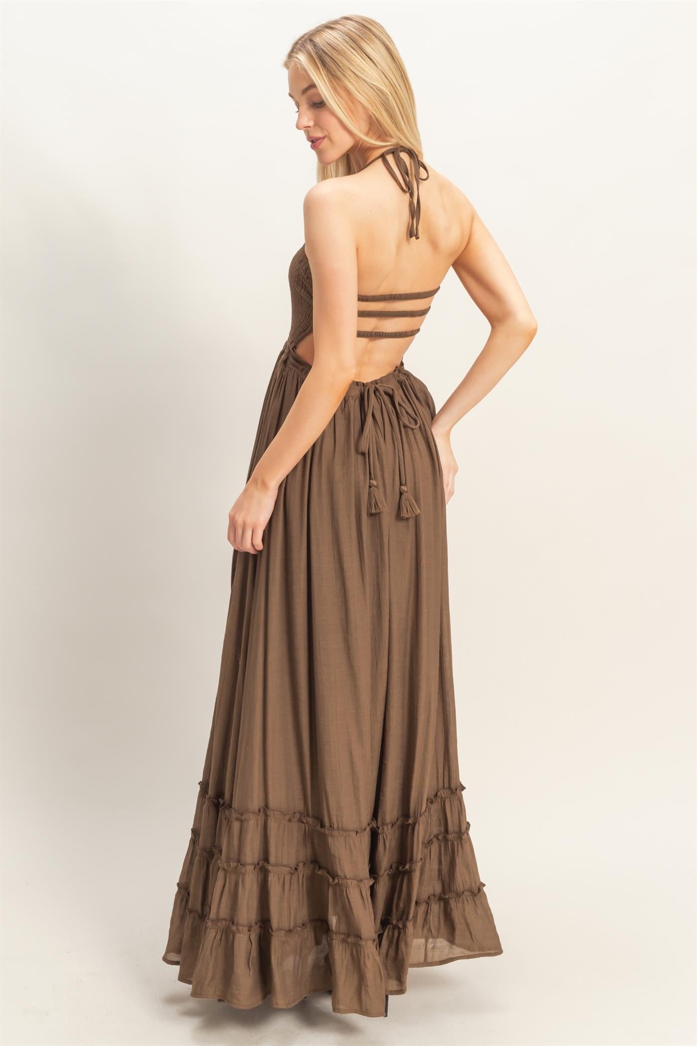 woman wearing a brown maxi dress with a strappy back and ruffle hem details