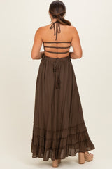woman wearing a brown maternity maxi dress with a back tie detail and ruffle hem