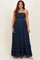 woman wearing a navy blue maternity maxi dress with a smocked bodice and tiered ruffles, showing baby bump