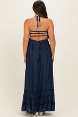 woman wearing a navy blue maternity maxi dress with a halter neck and strappy back detail