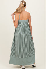 woman wearing a green and white striped maternity maxi dress with adjustable straps and a flowy silhouette