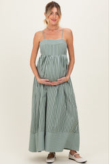woman wearing a green and white striped maternity maxi dress and holding her baby bump