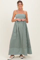 woman wearing a green and white striped maternity maxi dress with a fitted bodice and flowy skirt, baby bump visible