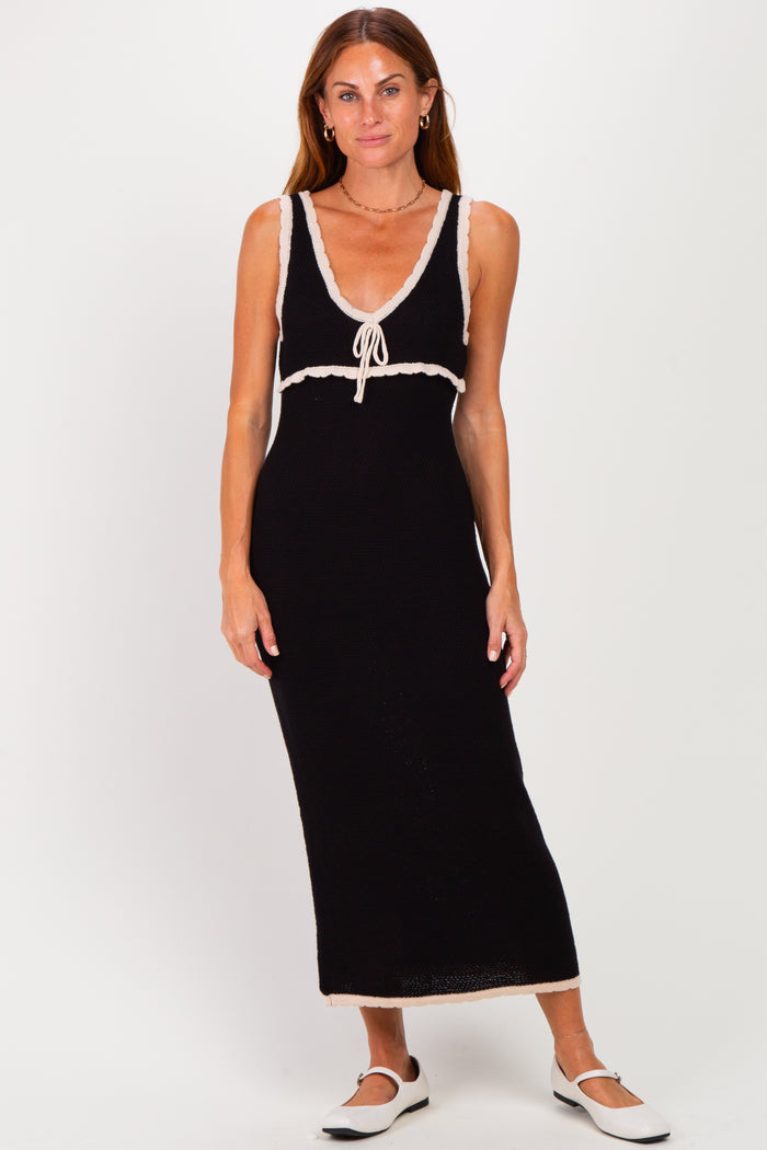 woman wearing a black sleeveless maxi dress with a v-neck and lace trim details