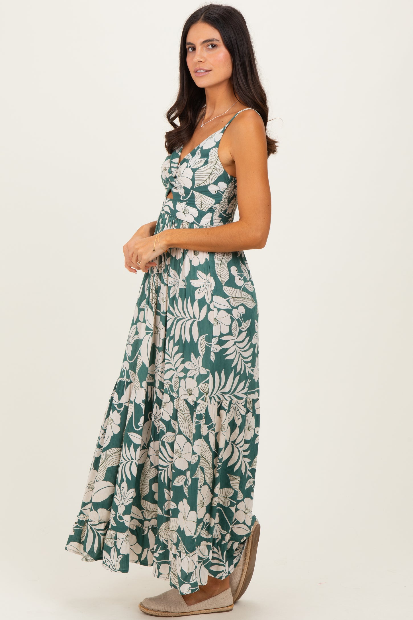 woman wearing a green floral maxi dress with a fitted bodice and spaghetti straps