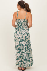 woman wearing a back view of a green floral maternity maxi dress with spaghetti straps