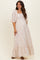 woman wearing a light pink floral maternity maxi dress with puff sleeves and a flowing skirt, baby bump visible