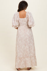 woman wearing a pink floral maternity maxi dress with puff sleeves and a smocked bodice, showing the back view