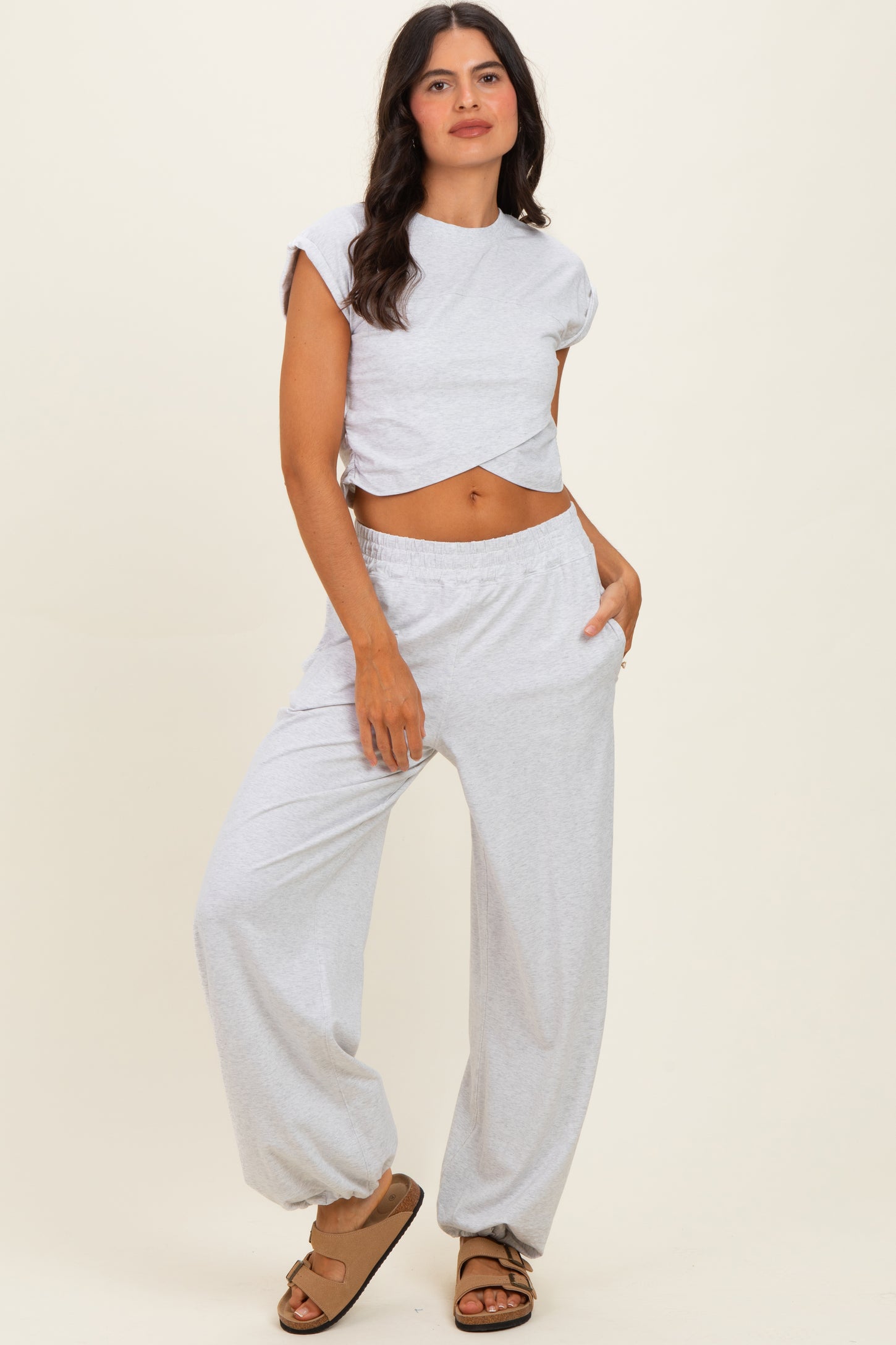 woman wearing a light gray cropped t-shirt and matching loose-fitting pants