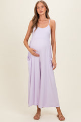 woman wearing a lavender maternity maxi dress with pockets and holding her baby bump