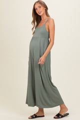 woman wearing a sage green maternity maxi dress with a flattering silhouette and visible baby bump