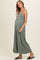 woman wearing a sage green maternity maxi dress with a flattering silhouette and visible baby bump