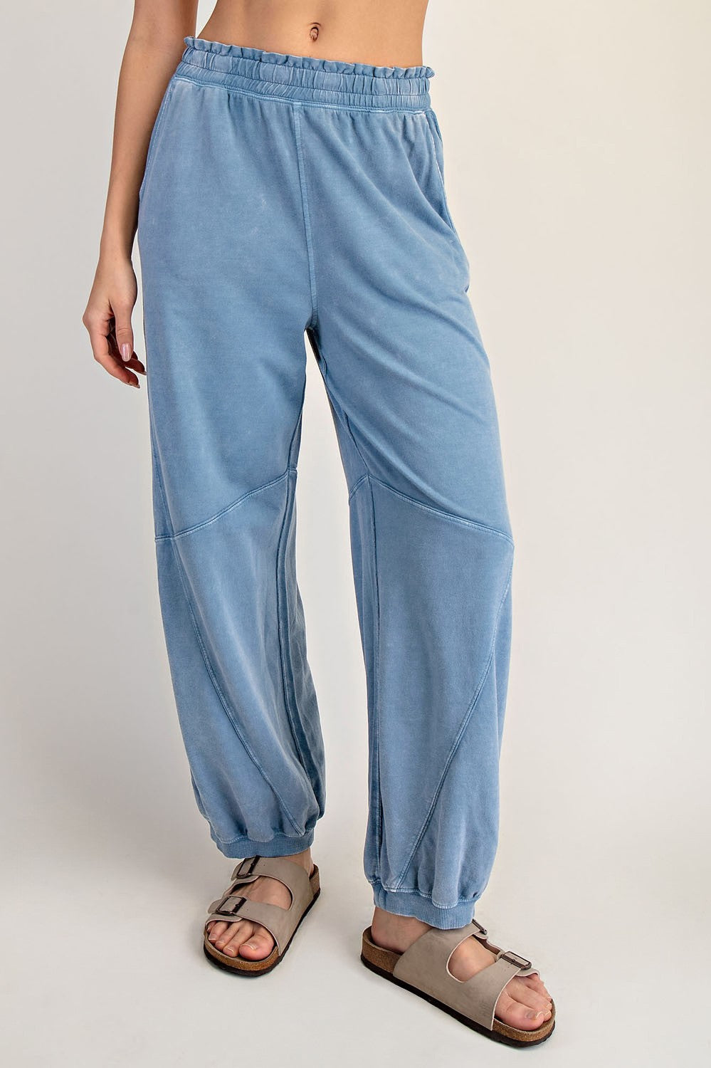 woman wearing light blue relaxed fit sweatpants with an elastic waistband and gathered cuffs