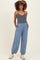 woman wearing a gray tank top and light blue maternity jogger pants with pockets and elastic cuffs