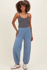 woman wearing a gray bodysuit and light blue maternity jogger pants with gathered ankles and side pockets