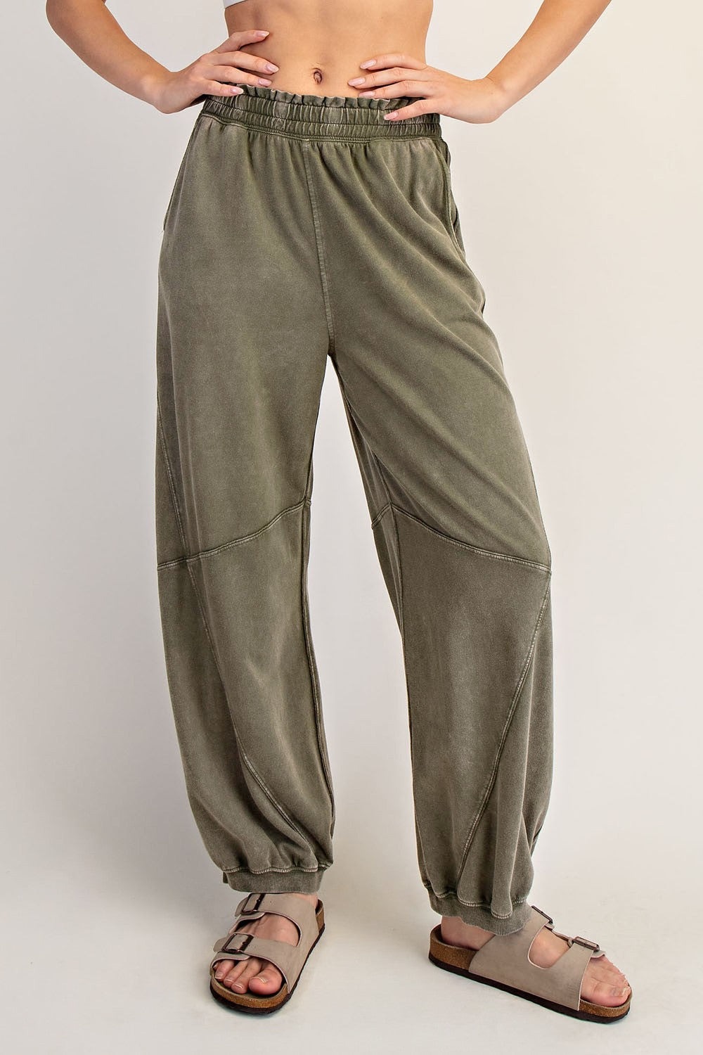 woman wearing olive green relaxed fit sweatpants with elastic waistband and tapered cuffs