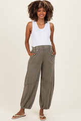 woman wearing a white button-up maternity tank top and olive green maternity jogger pants with pockets
