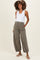 woman wearing a white sleeveless maternity tank top and olive green maternity jogger pants with pockets