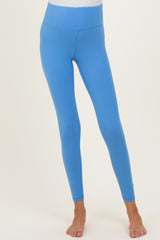 woman wearing bright blue maternity leggings with a high waistband